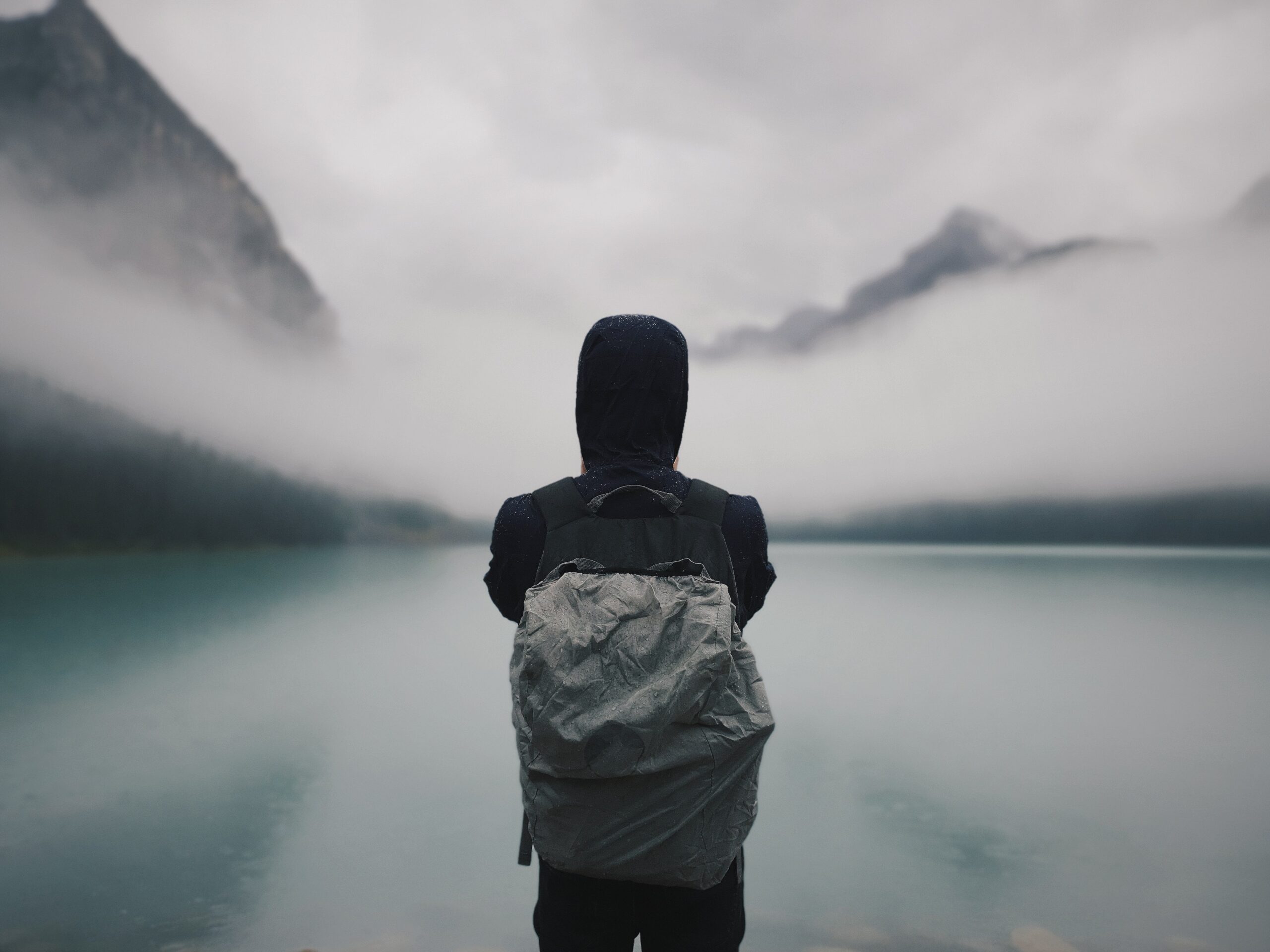 A man standing near a lake – spending time in nature is a way to prevent burnout