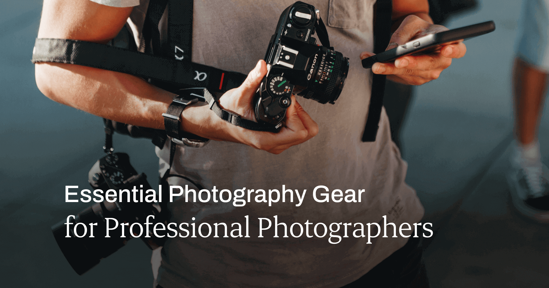 Essential Photography Tools & Gear for Professional Photographers Person holding a phone and a camera, with another camera slung over their shoulder. Title text on the image: Essential Photography Gear for Professional Photographers