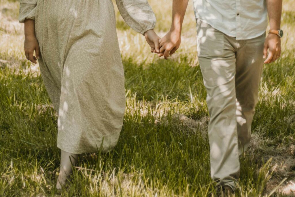 Close-up shot of couple holding hand with flattering light falling on them